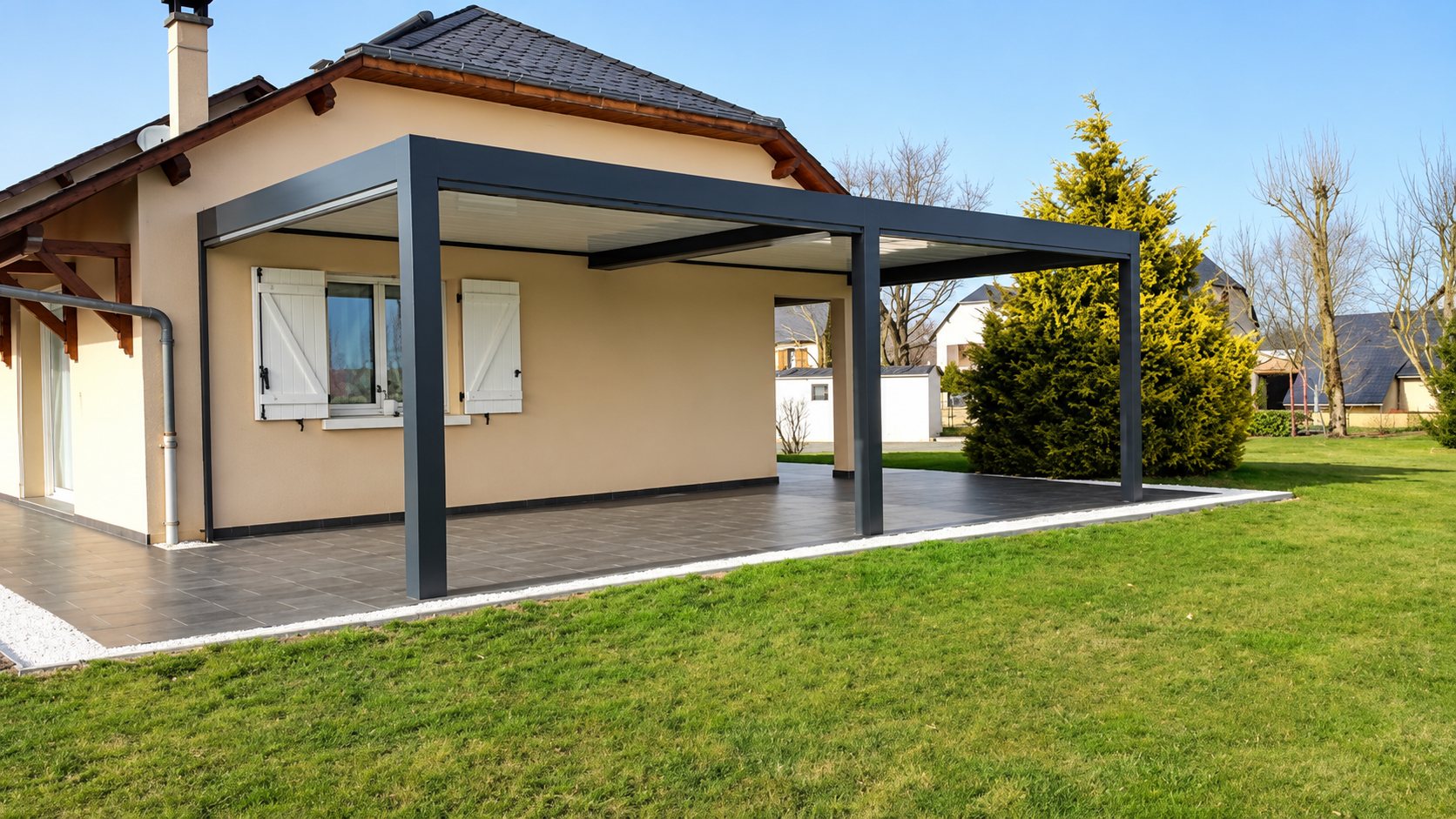 Pergola bioclimatique grise sur terrasse carrelée devant une maison de plain-pied